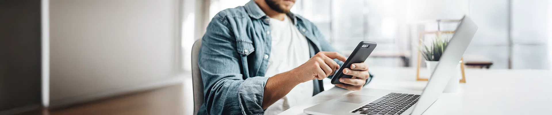 Image of man selecting services to bundle on mobile phone and laptop for selection of services provided by CDE Lightband