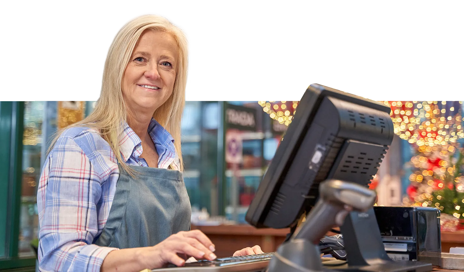 Woman shopkeeper, smiling, using POS system for business requiring CDE Lightband services