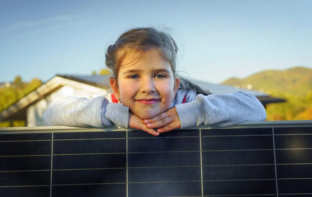 Image of little girl next to solar panel