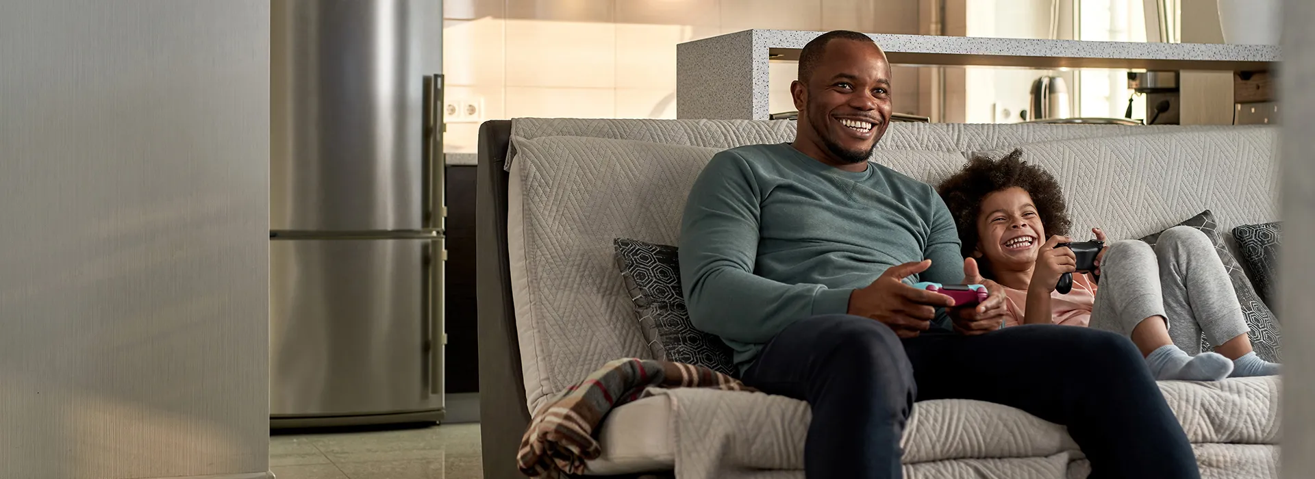 Image of father and son hanging out on the couch, relaxing and playing some video games after having CDE service transferred to their new home