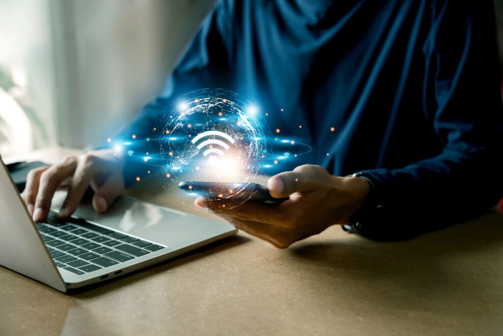 Person using laptop, computer, and mobile device with Wi-Fi service